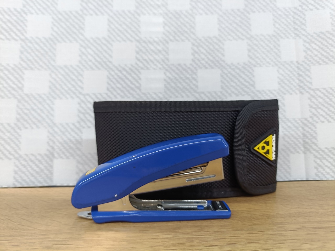 TOPEAK ラチェットロケット ライト DX の収納バッグとホッチキスのサイズ比較